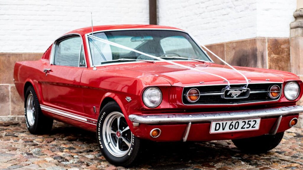 Ford Mustang vermelho clássico e bem conservado, ilustrando o dilema de contratar seguro para carro antigo.