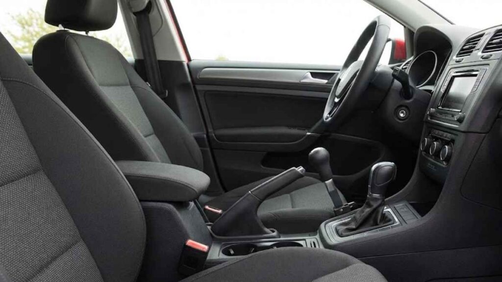 Interior de carro com adaptação veicular (alavanca de freio e acelerador manual) instalada no console central, exemplificando equipamento que deve ser declarado no seguro auto para PCD.