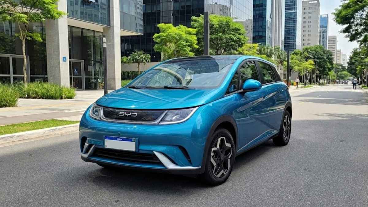 Carro elétrico BYD Dolphin azul estacionado em uma rua urbana com prédios comerciais ao fundo, ilustrando o artigo sobre o seguro do BYD Dolphin.