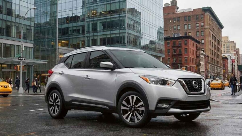 Nissan Kicks 2018 na cor prata circulando em uma rua urbana movimentada, servindo de exemplo para a cotação de seguro do kicks seminovo.